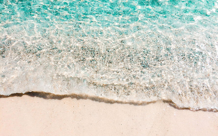 Turquoise ocean waves washing over a pristine white sandy beach shoreline HD wallpaper