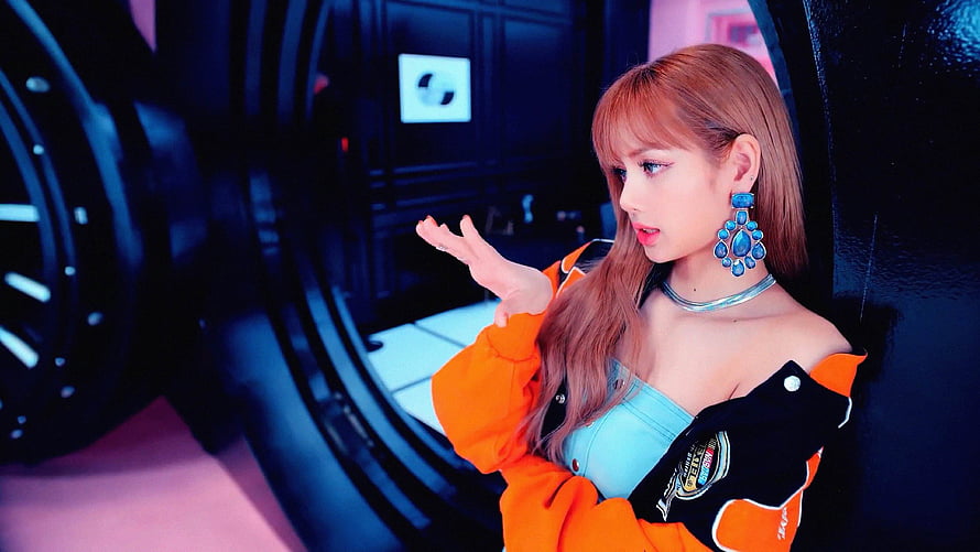Lisa from BLACKPINK in vibrant orange jacket and blue top with statement earrings HD wallpaper