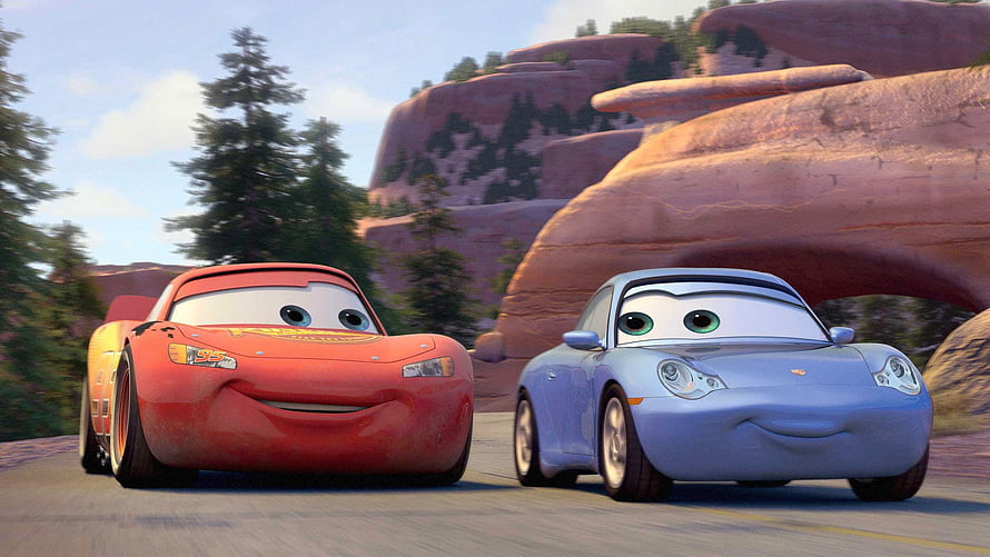 Lightning McQueen and Sally Carrera driving together on a scenic road in the animated movie Cars HD wallpaper