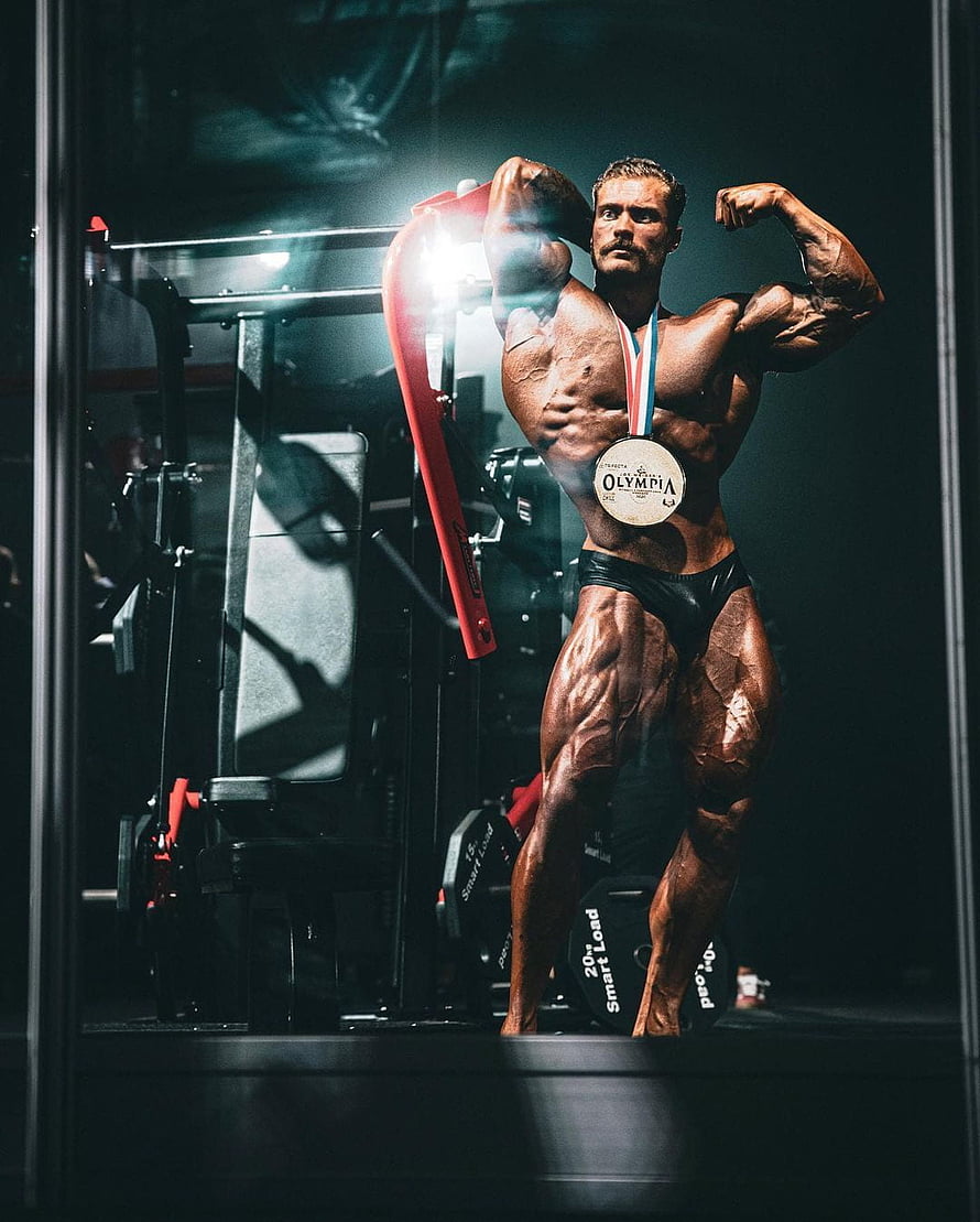 Muscular Bodybuilder Flexing With Olympia Medal In Dark Gym HD phone wallpaper