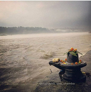 Shiva Lingam by the River Ganges at Haridwar with Morning Mist and Offerings HD phone wallpaper