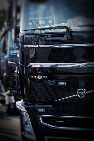 Close-up of a black Volvo truck front grille with chrome accents and mesh detailing HD phone wallpaper