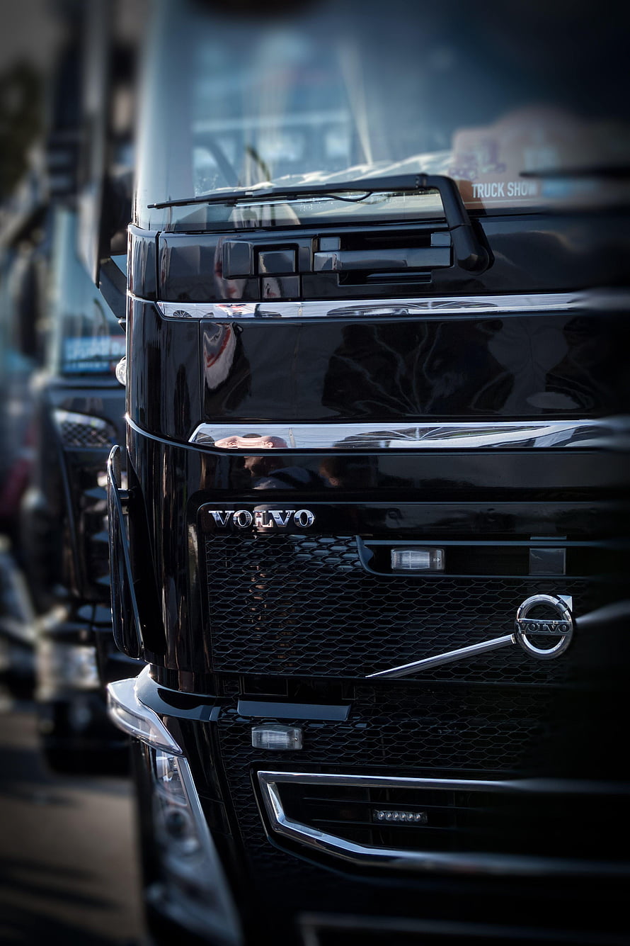 Close-up of a black Volvo truck front grille with chrome accents and mesh detailing HD phone wallpaper