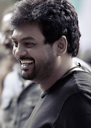 Portrait of a smiling man with dark hair and beard wearing a black t-shirt, Puri Jagannadh, puri jagannath director HD phone wallpaper