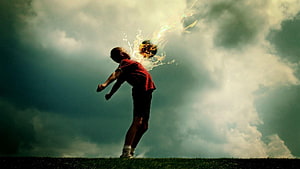 Dramatic Soccer Player Silhouette Kicking Ball Against Stormy Sky HD wallpaper