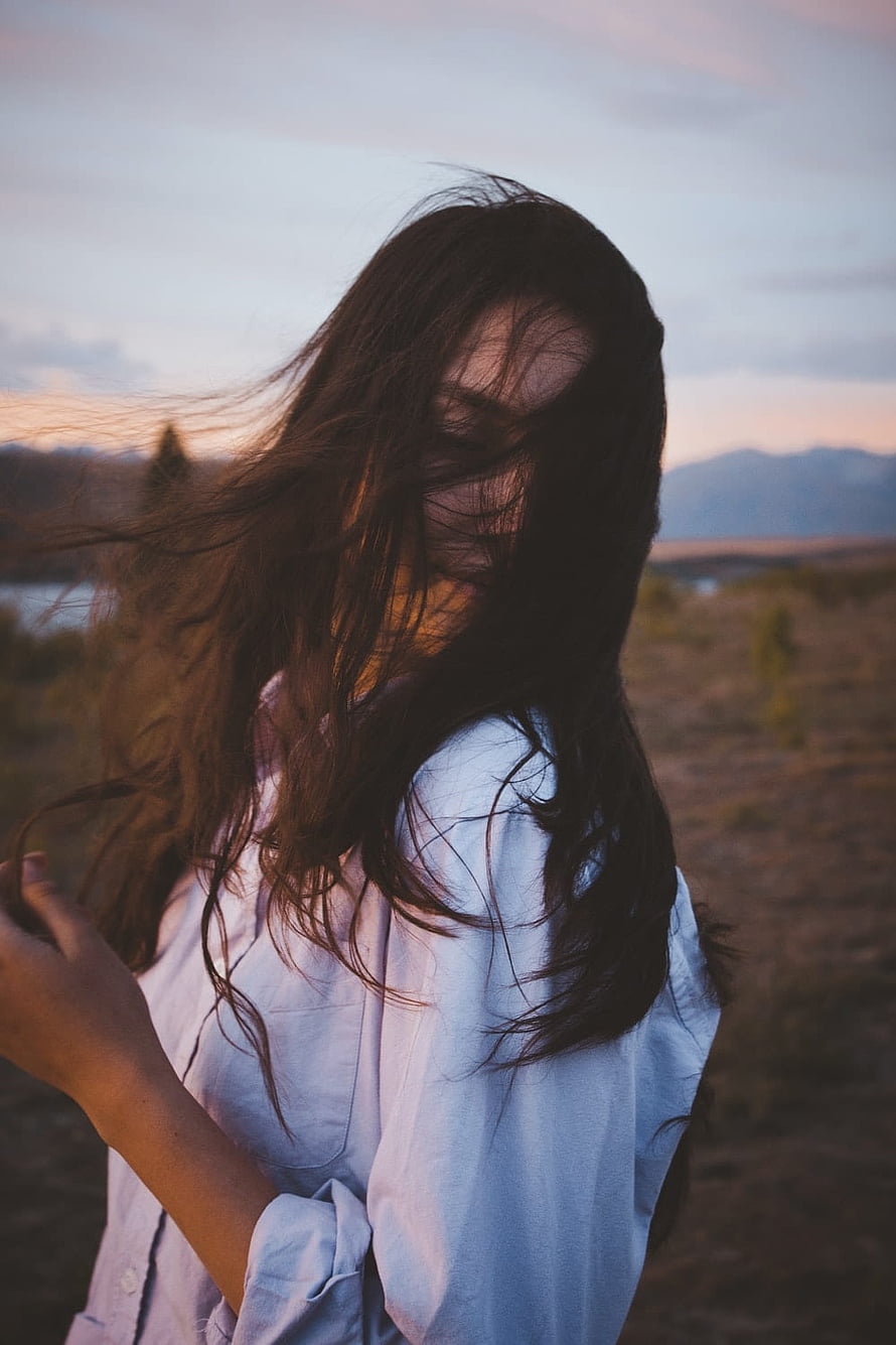 Woman with windblown hair covering face in a white shirt at sunset, 50 Hidden Face, girls hidden dp HD phone wallpaper