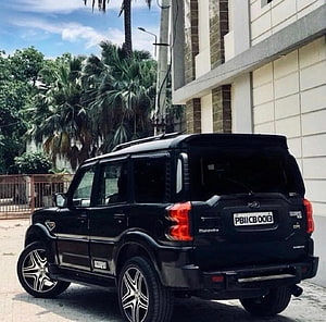 Black Mahindra Scorpio S11 SUV with Custom Alloy Wheels Parked on Urban Street HD wallpaper