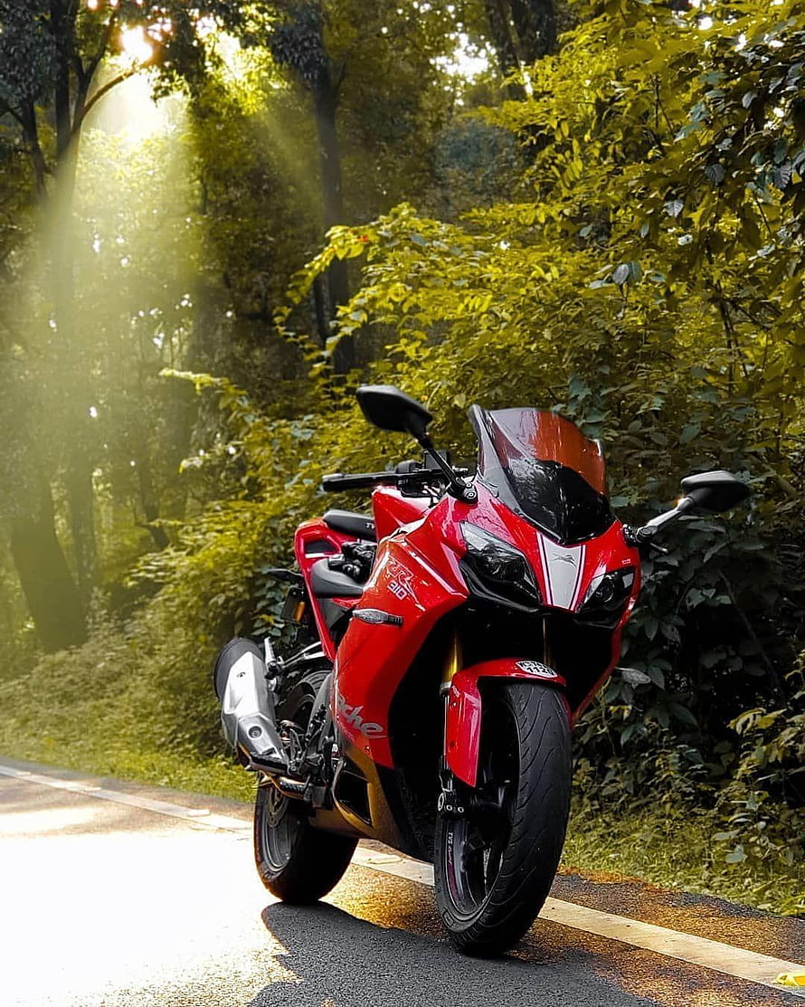 Red KTM RC 390 sport bike parked on a forest road with sunbeams filtering through the trees HD phone wallpaper