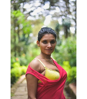 Resmi Nair in a red sari and yellow lace bralette in a lush green garden HD phone wallpaper
