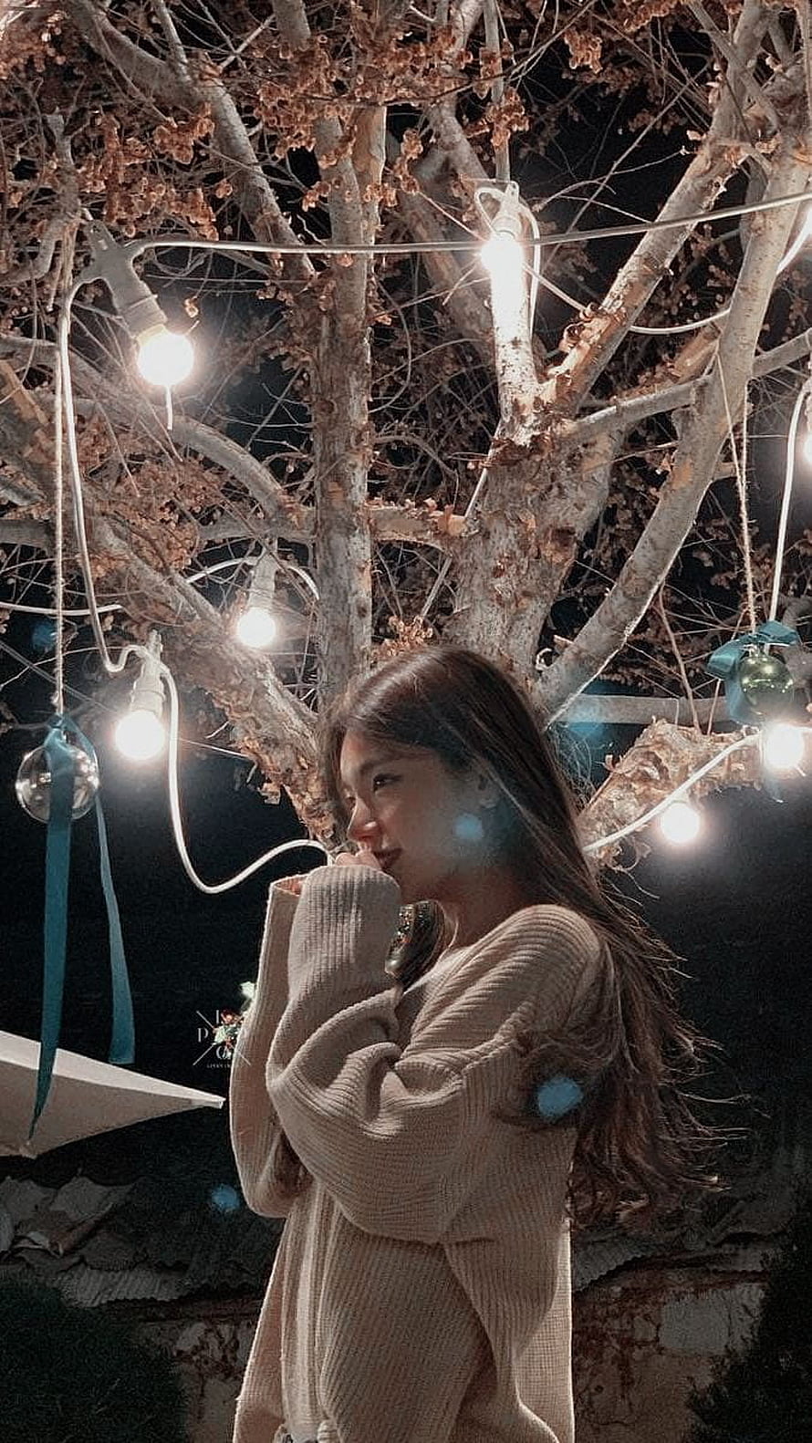 Hwang Yeji from ITZY in a cozy knit sweater under warm string lights at night HD phone wallpaper