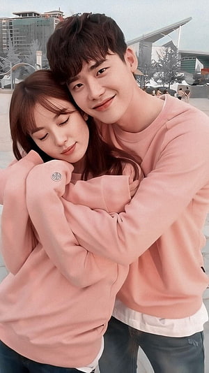 Korean Drama Couple in Matching Pink Sweaters Embracing Outdoors HD phone wallpaper