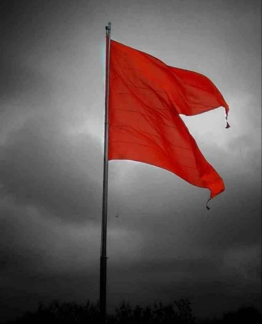 Vibrant Red Flag Waving Against a Dark Stormy Sky HD phone wallpaper