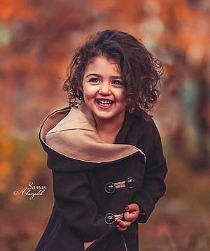 Anahita Hashemzadeh Smiling in a Black Coat Against an Autumn Background HD phone wallpaper
