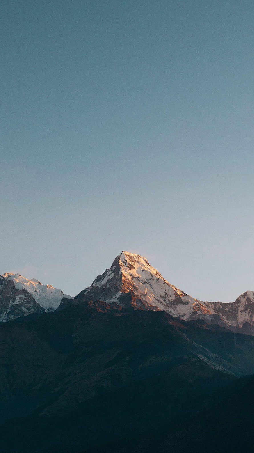 Snow-Capped Mountain Peak Bathed in Golden Sunrise Light Against a Clear Blue Sky HD phone wallpaper