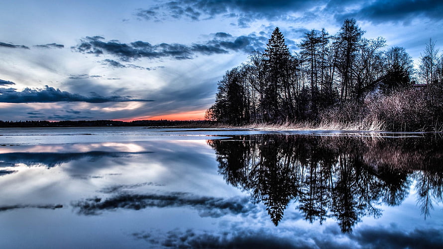 Serene Winter Lake at Dusk with Pine Tree Reflections and Dramatic Clouds HD wallpaper