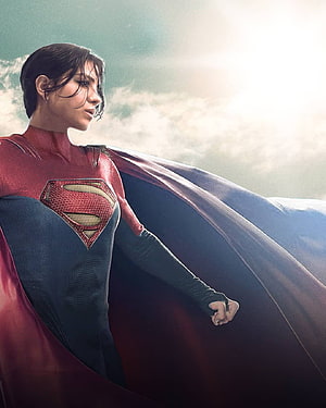 Supergirl in red and blue suit with flowing cape against bright sky HD phone wallpaper