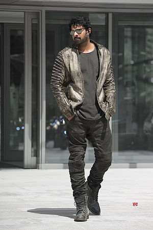 Pawan Kalyan in rugged leather jacket and sunglasses walking outdoors HD phone wallpaper