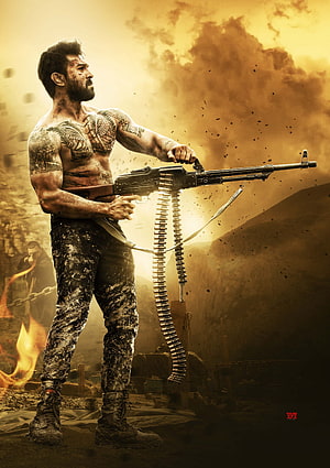 Ram Charan in Vinaya Vidheya Rama holding a machine gun in a fiery battlefield scene HD phone wallpaper