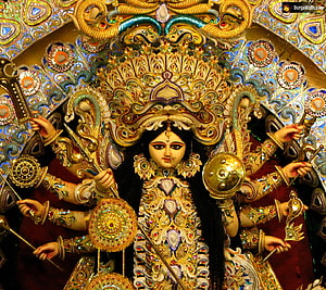 Ornate Golden Idol of Goddess Durga with Multiple Arms Holding Weapons and Shields HD wallpaper
