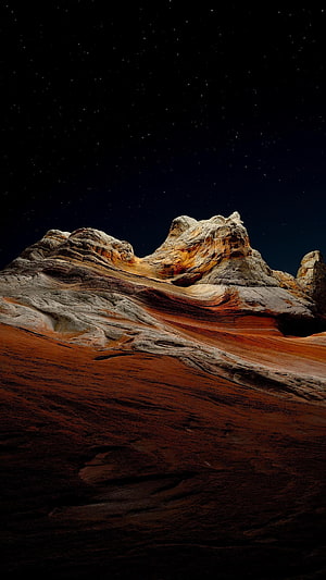 Dramatic Desert Rock Formation Under a Starry Night Sky HD phone wallpaper