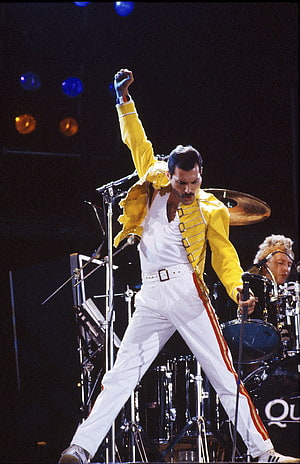 Freddie Mercury Performing Live in Iconic Yellow Jacket and White Trousers HD phone wallpaper