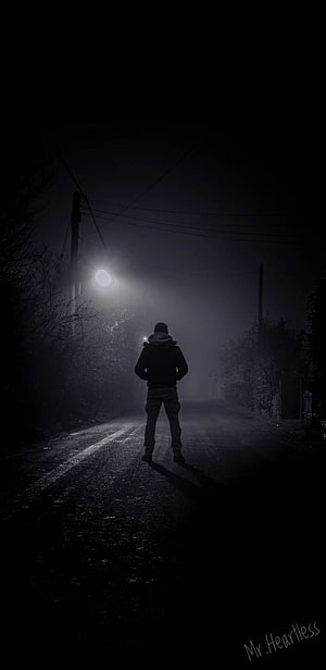 Lonely figure standing on a dark foggy road at night under a streetlight HD phone wallpaper