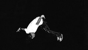 Black and White Photo of a Breakdancer Performing an Aerial Move Against a Dark Background HD wallpaper
