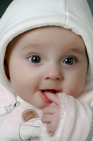Cute baby with blue eyes wearing a white hooded outfit and sucking thumb HD phone wallpaper