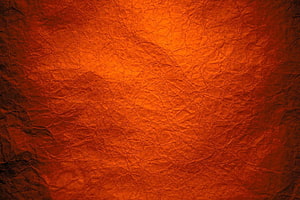 Textured Orange Crumpled Paper Background With Deep Wrinkles And Warm Lighting HD wallpaper