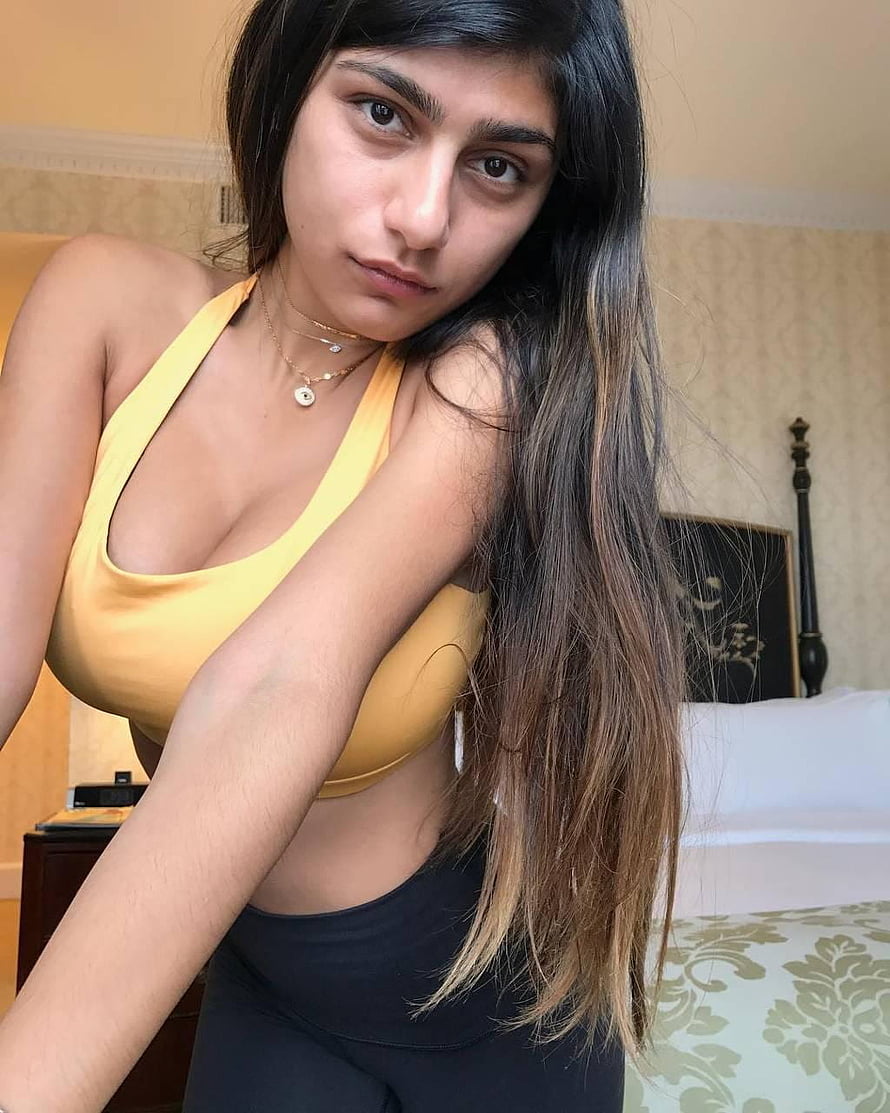 Woman in yellow halter top and black leggings posing in bedroom with long ombre hair, Mia Khalifa by Gurusad, mia khalifa HD phone wallpaper