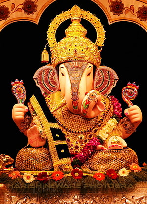 Ornate Golden Ganesha Murti Adorned With Jewels And Floral Garlands HD phone wallpaper