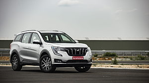 White Mahindra XUV700 SUV on an open tarmac track under an overcast sky HD wallpaper