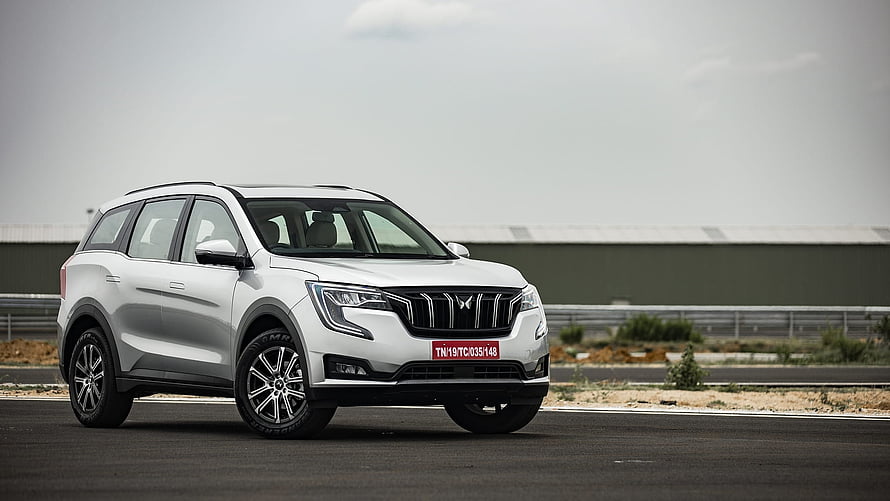 White Mahindra XUV700 SUV on an open tarmac track under an overcast sky HD wallpaper