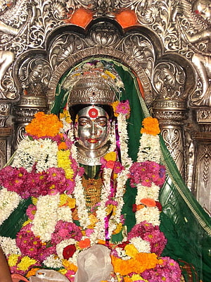 Silver Maa Kali Idol Adorned With Colorful Flower Garlands And Ornate Temple Shrine HD phone wallpaper