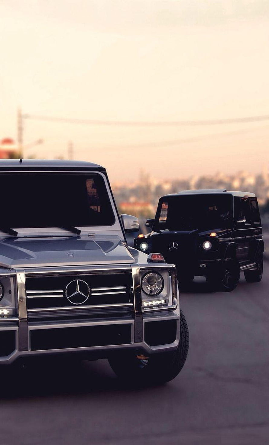 Silver and Black Mercedes-Benz G-Class SUVs Driving on Road at Sunset HD phone wallpaper