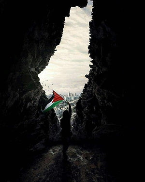 Silhouette of person holding Palestinian flag in rocky cave opening overlooking city skyline HD phone wallpaper