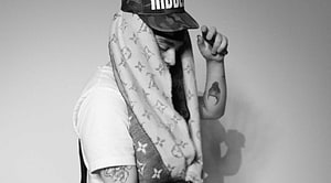 Black and white portrait of a person wearing a Louis Vuitton scarf and a cap with tattoos HD wallpaper