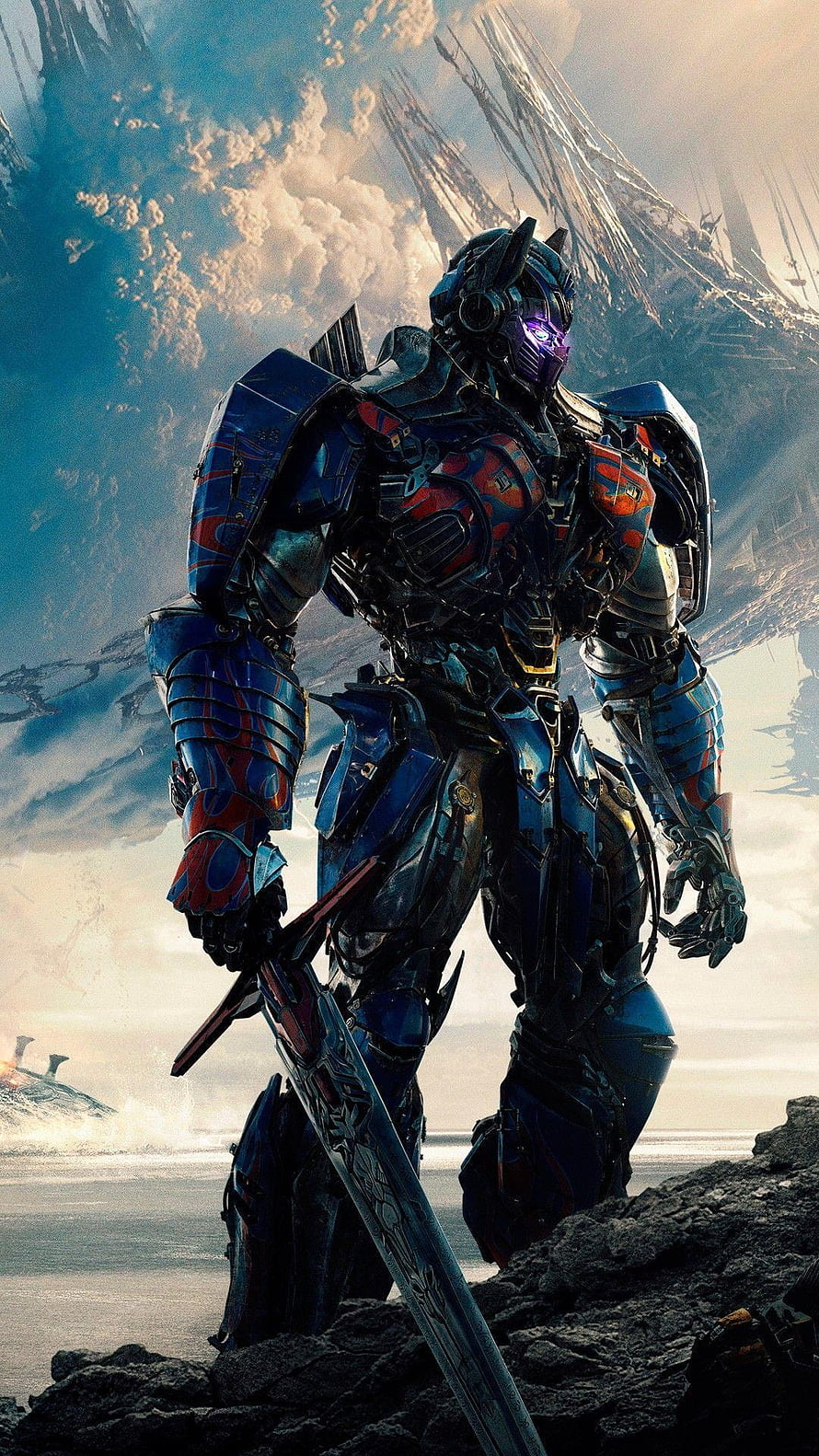 Optimus Prime wielding a sword in a dramatic sci-fi landscape with mountains HD phone wallpaper
