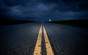 Empty Highway Stretching Into Dark Stormy Horizon With Yellow Lines HD wallpaper
