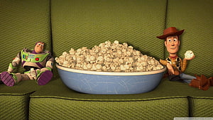 Toy Story Buzz Lightyear and Woody Sitting on a Green Couch with a Large Bowl of Popcorn HD wallpaper