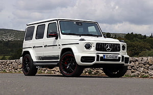 White Mercedes-AMG G 63 SUV with Black and Red Wheels on a Scenic Road HD wallpaper