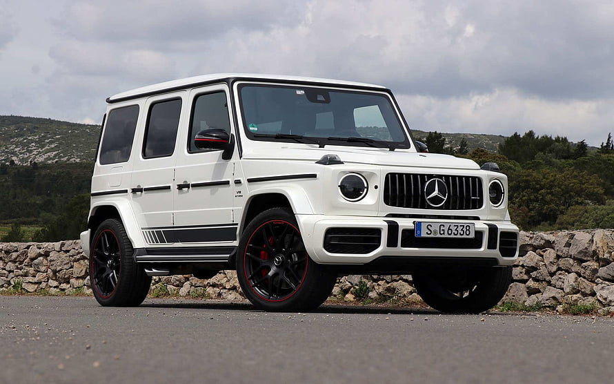 White Mercedes-AMG G 63 SUV with Black and Red Wheels on a Scenic Road HD wallpaper