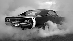 Black 1968 Dodge Charger R/T performing a burnout in thick tire smoke HD wallpaper