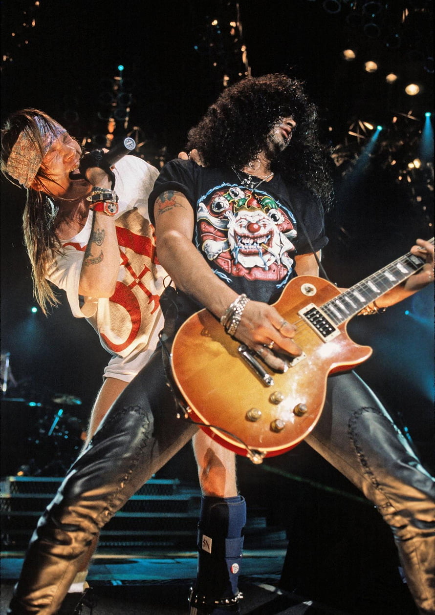 Slash and Axl Rose performing live on stage with electric guitar and microphone HD phone wallpaper