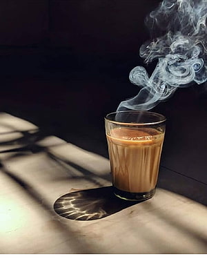 Steaming Glass of Chai on a Sunlit Marble Surface with Dramatic Shadows HD phone wallpaper