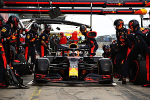 Red Bull Racing Formula 1 car during a pit stop with crew members HD wallpaper
