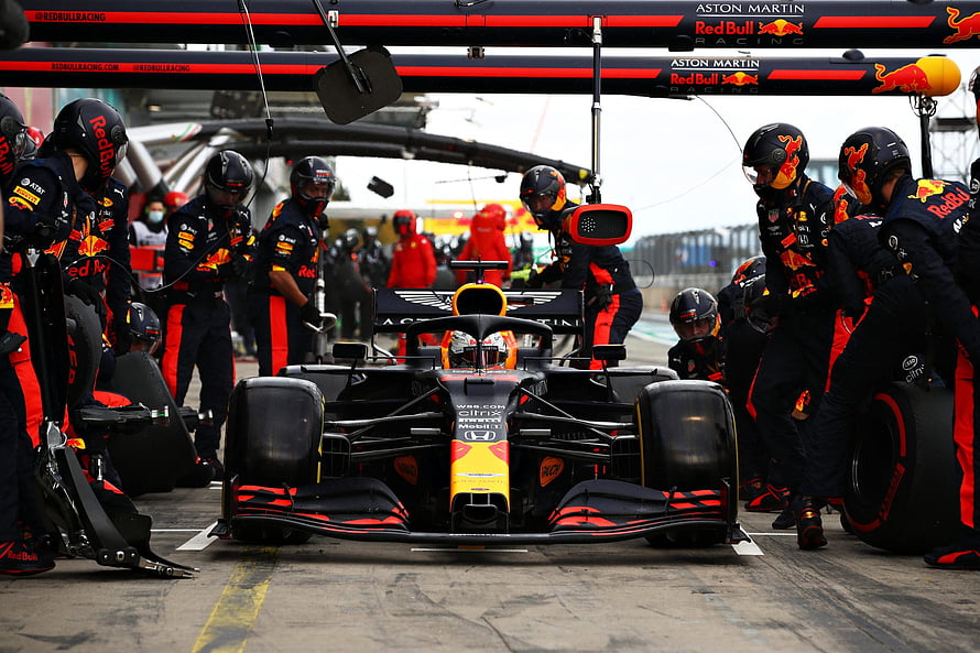 Red Bull Racing Formula 1 car during a pit stop with crew members HD wallpaper