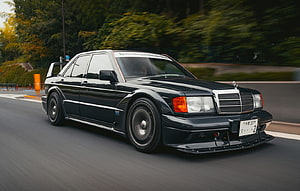 Black Mercedes-Benz 190E Evolution II Widebody Sedan Driving on a Forest Road HD wallpaper