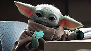 Grogu from The Mandalorian holding a blue snack in a brown robe HD wallpaper