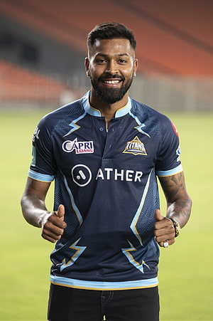 Gujarat Titans Player Portrait in Navy Blue Ather Jersey on Cricket Field HD phone wallpaper